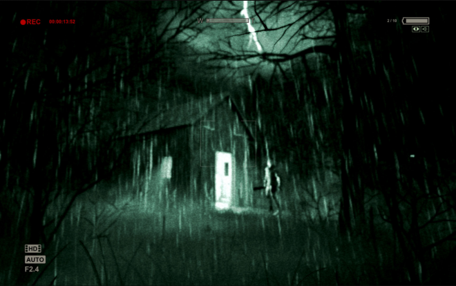 Screenshot of the game "Outlast", on which you see an abandoned house in dark woods.